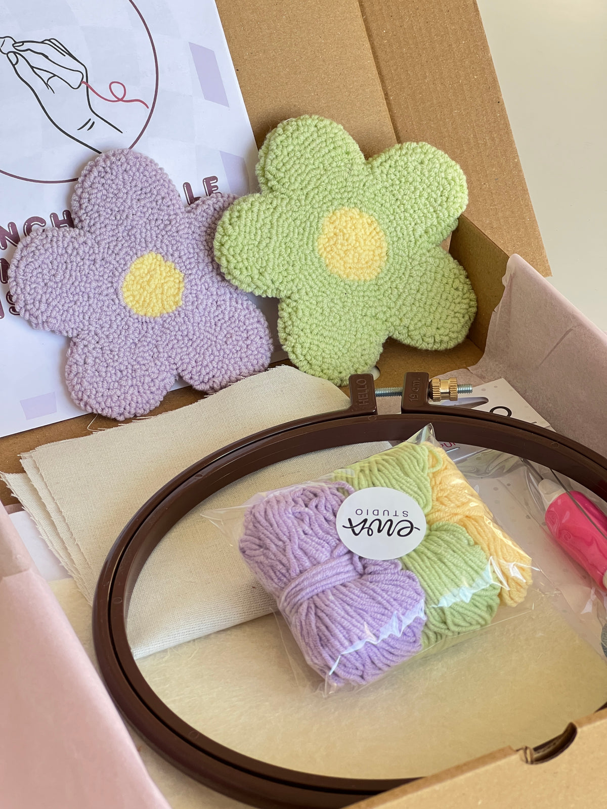 Punch needle kit box with lilac and green daisy coasters, yarn, hoop and needle
