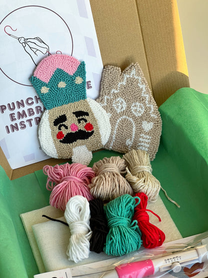 Punch needle kit box with nutcracker and gingerbread house coasters, yarn, hoop and needle