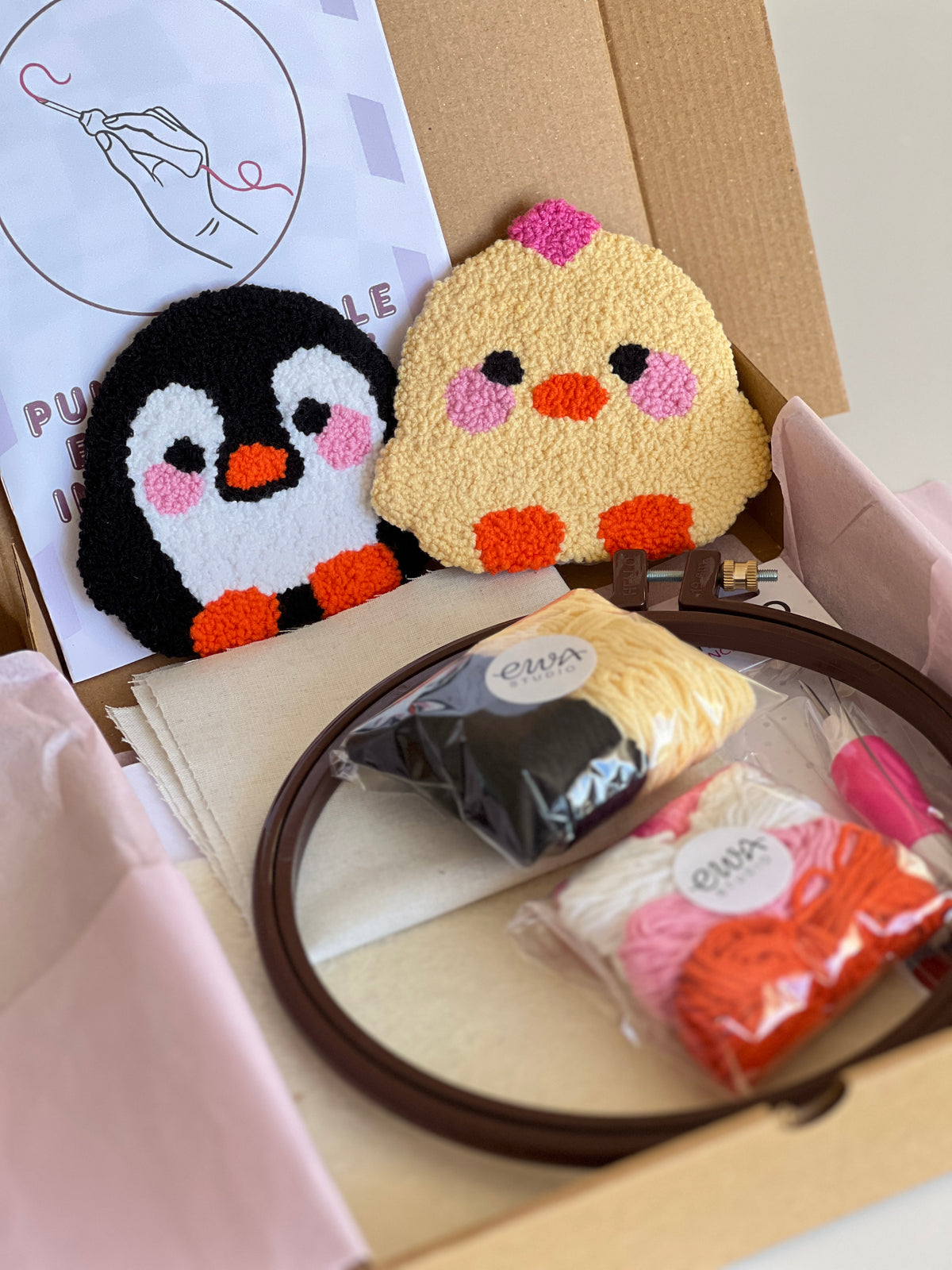 Punch needle kit box with chick and penguin coasters, yarn, hoop and needle