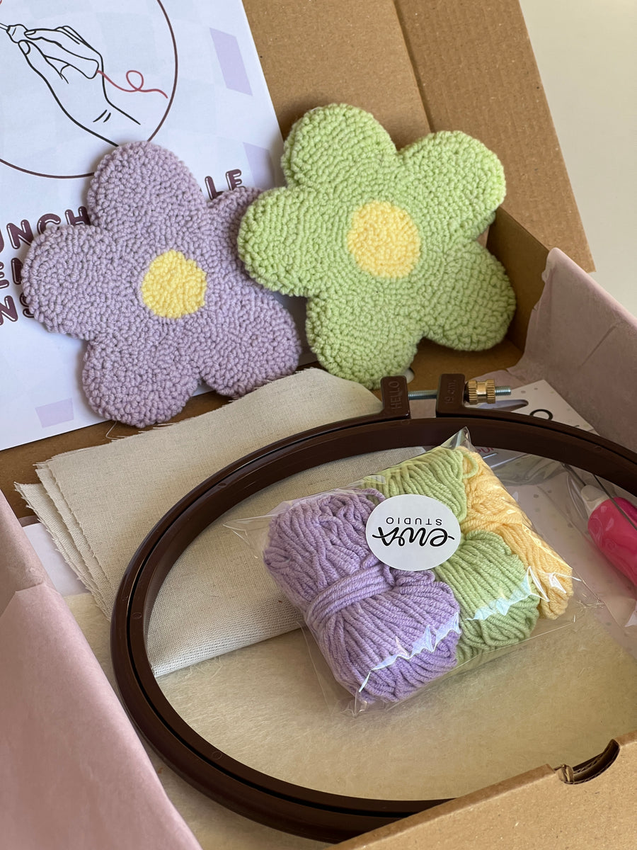 Punch needle kit box with lilac and green daisy coasters, yarn, hoop and needle